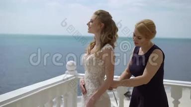 伴娘<strong>蕾丝礼服</strong>新娘在露台上。海上婚礼。